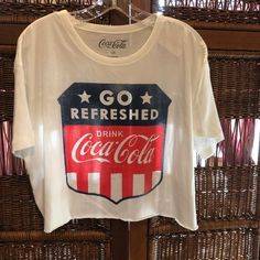 Coca Cola Tee Shirt White T-shirt With American Flag Print For Spring, Red Short Sleeve Tops For 4th Of July, Patriotic Red Short Sleeve Tops, Red Patriotic Short Sleeve Tops, American Flag Print Crew Neck Top For Spring, White Retro Top For 4th Of July, Red Casual Shirt With Flag Print, Trendy Crew Neck Top For 4th Of July, Casual Red Shirt With Flag Print