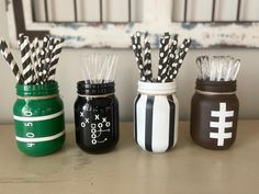 three mason jars with black and white striped paper straws in them on a table