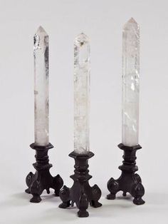 three crystal candlesticks sitting next to each other on top of a white surface