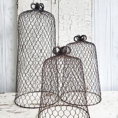 two wire baskets with bows on them sitting next to each other