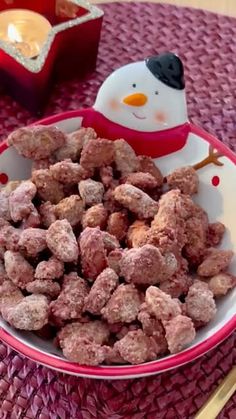 a bowl filled with dog food next to a snowman