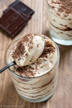 two glasses filled with ice cream on top of a wooden table