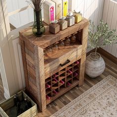 a wooden cabinet with wine bottles and candles on it next to a potted plant