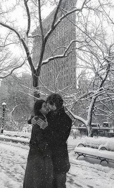 a man and woman kissing in the snow