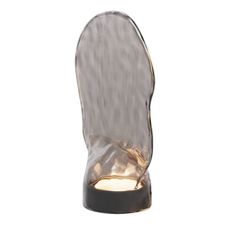 a light that is on top of a glass shoe shaped object in the shape of a foot