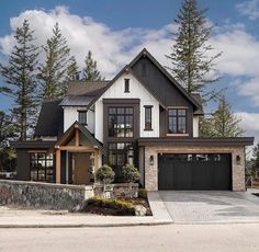 a large house with two garages and lots of windows on the front of it