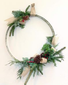 a christmas wreath with pine cones and evergreens