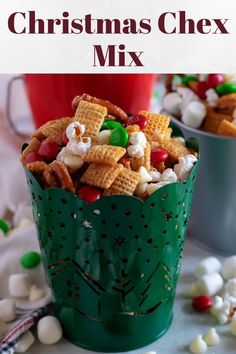 christmas chex mix in a green cup with candy and marshmallows on the side