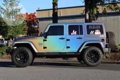 a blue and green jeep parked in front of a building