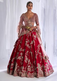 a woman in a red and gold wedding gown standing with her hands on her hips