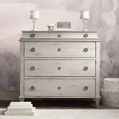 a white dresser with two candles on top