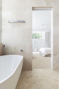 a large white bath tub sitting next to a bathroom sink under a mirror on the wall