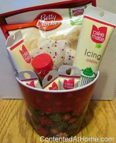 a cup filled with lots of food on top of a wooden table next to a box