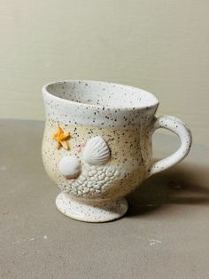 a ceramic cup with shells and starfish on it