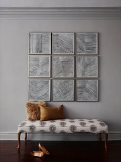 a white bench sitting in front of a wall with pictures on it's side