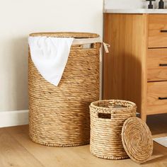 two woven baskets sitting next to each other on the floor in front of a sink