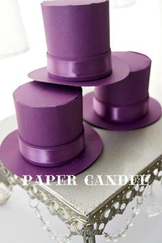 three purple hats are stacked on top of each other