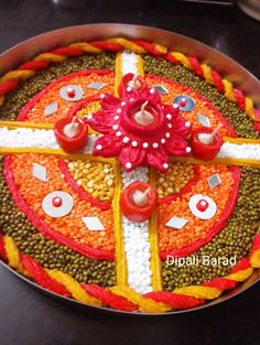 a cake decorated with red, white and yellow decorations on top of a metal pan