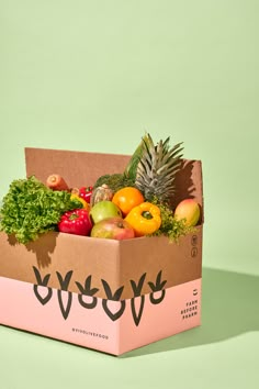 a box filled with lots of different types of fruits and vegetables on top of a green surface