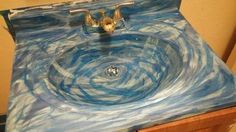 a sink that is painted with blue and white swirls