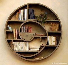 a circular shelf with books on it and a plant in the middle is mounted to the wall