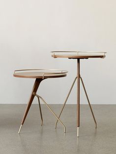 two tables sitting on top of each other in front of a white wall and floor