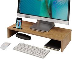 a computer desk with a keyboard, mouse and cell phone on it in front of a monitor