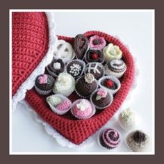 there are many crocheted cupcakes in the heart shaped bag on the table