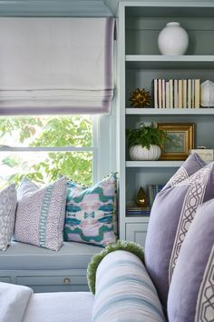 a living room filled with lots of furniture and pillows