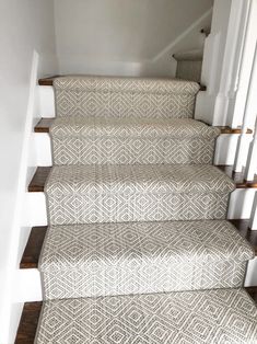 a set of stairs with carpeted treads and wooden handrails in a home