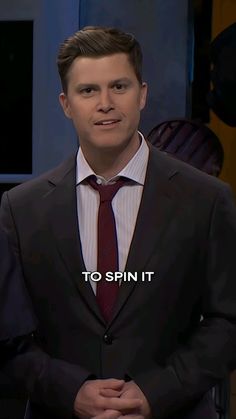 a man in a suit and tie with the words to spin it on his chest