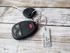 a car keychain that is sitting on top of a wooden table with a tag attached to it