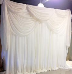 a white curtain is hanging on the wall in front of a stage set up for an event