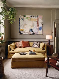 a living room filled with furniture and a painting on the wall