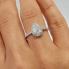 a woman's hand with a diamond ring on top of her finger and an engagement band