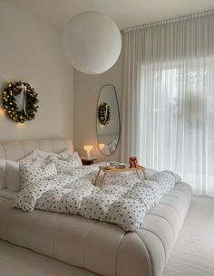 a white bed sitting in a bedroom next to a window