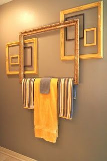 a bathroom with towels hanging on the wall and pictures hung to the wall above it