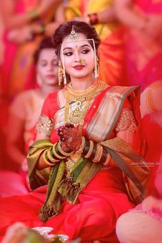 a woman in red and gold sitting on the ground