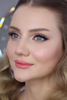 a woman with blonde hair and blue eyes is posing for a photo in front of the camera