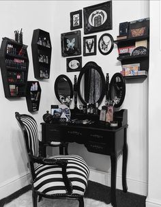 a black and white striped chair sitting in front of a desk with mirrors on it