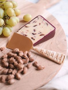 grapes, cheese and crackers on a wooden plate