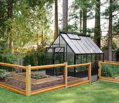 a small greenhouse in the middle of some grass