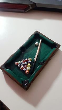 a pool table with billiards, cues and balls on it in front of a computer keyboard