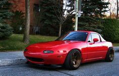 a red sports car is parked on the street