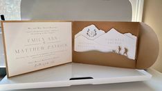 the inside of a wedding card is open to show it's mountain scene and silhouettes