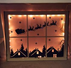 a lighted window with santa's sleigh in the sky