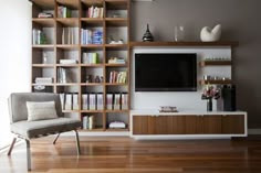 a living room filled with furniture and a flat screen tv on top of a wooden shelf