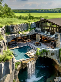 an aerial view of a house with a pool and waterfall in the middle of it