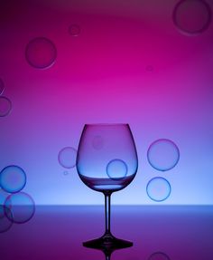 a wine glass sitting on top of a table covered in water bubbles and soapy liquid