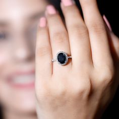 a woman's hand with a ring on it and a blue stone in the middle